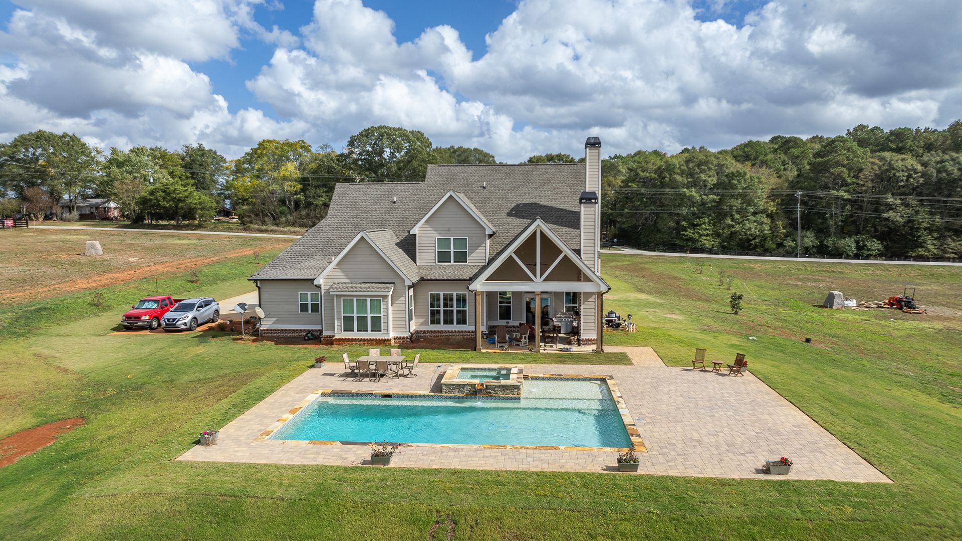 An aerial view of a house with a large swimming pool in the backyard.