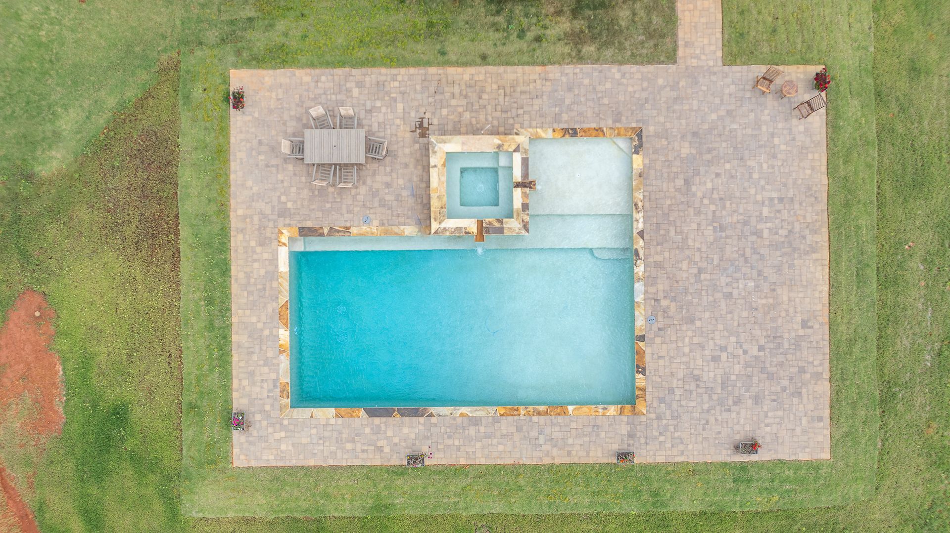 An aerial view of a large swimming pool surrounded by grass.