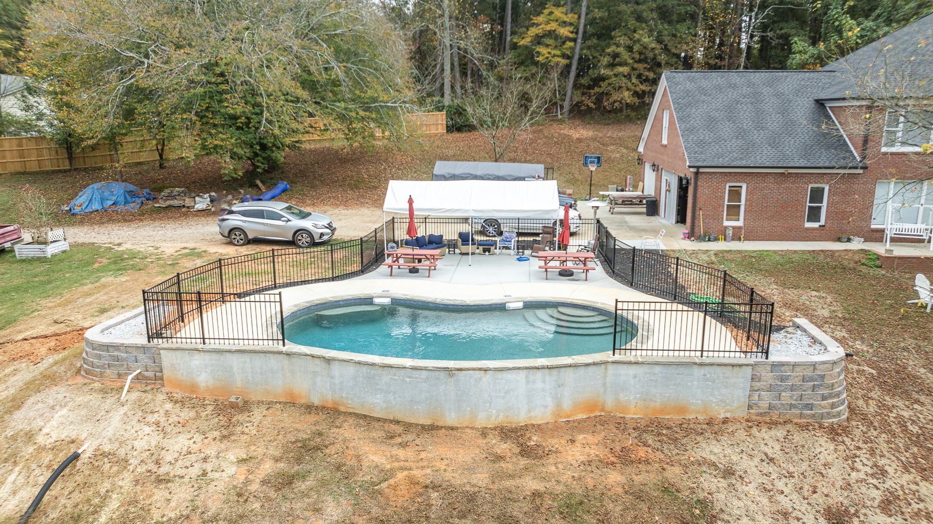 An aerial view of a large swimming pool in the backyard of a house.