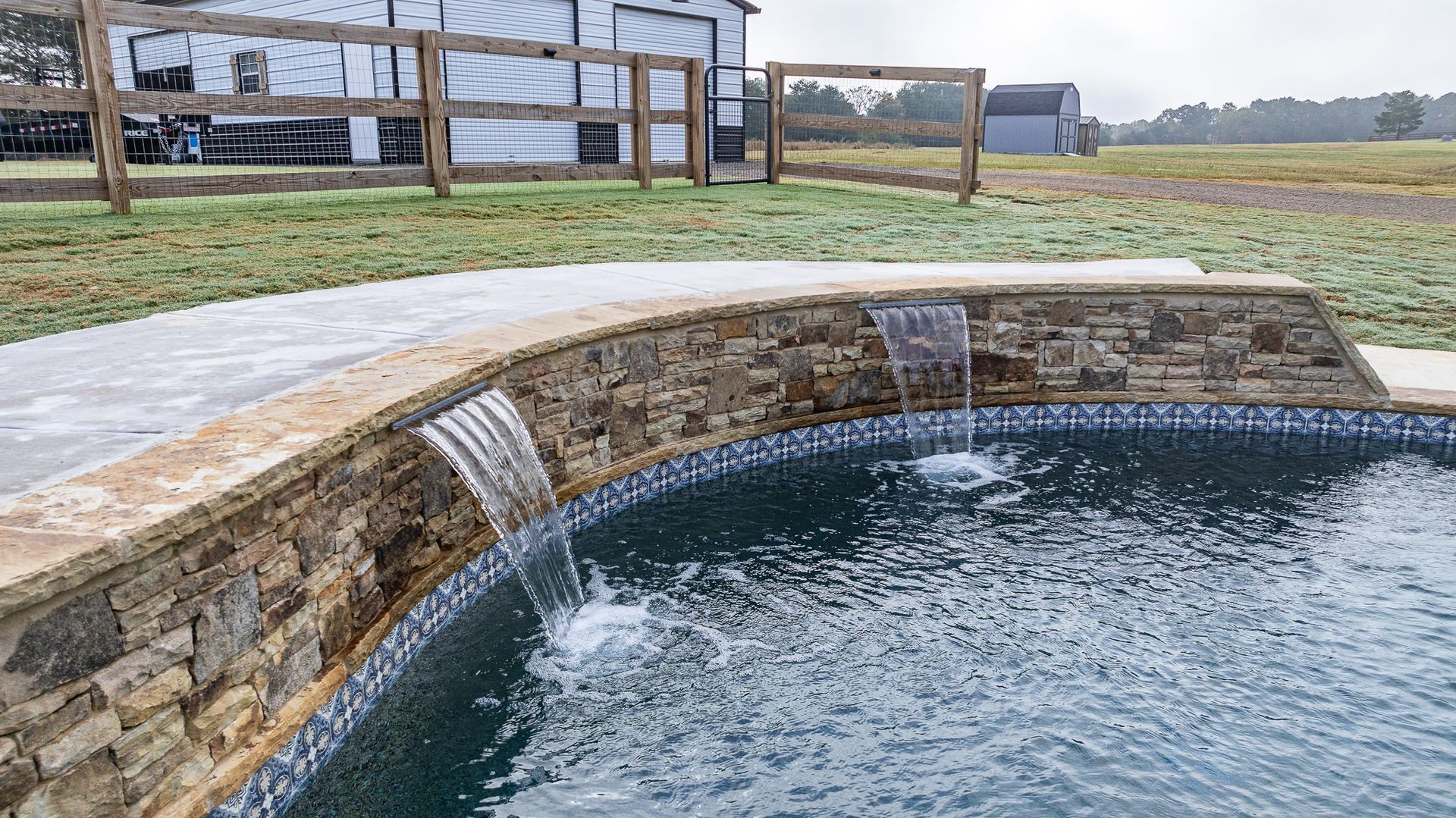 A swimming pool with a waterfall in the middle of it.