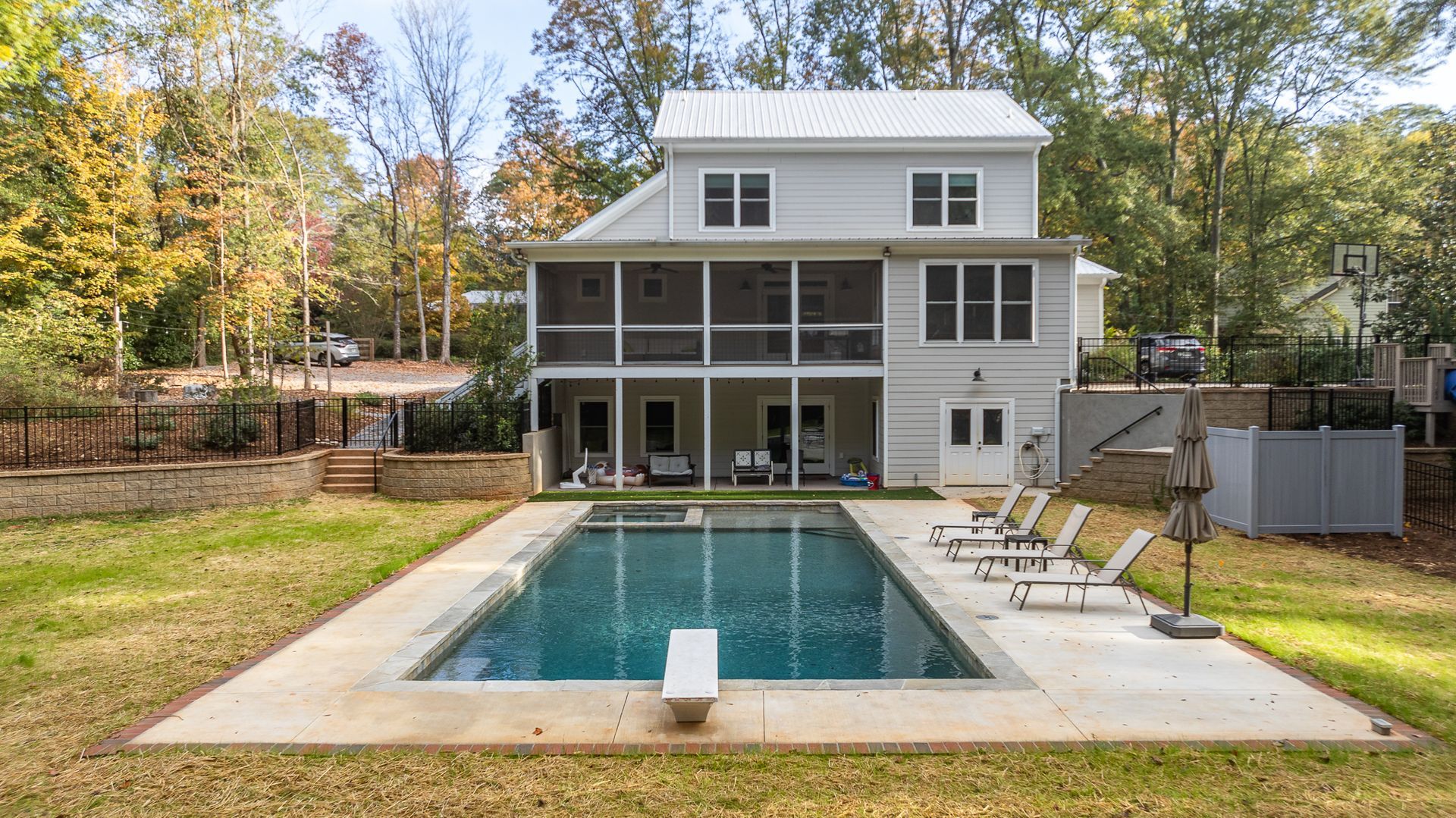A large white house with a large swimming pool in the backyard.