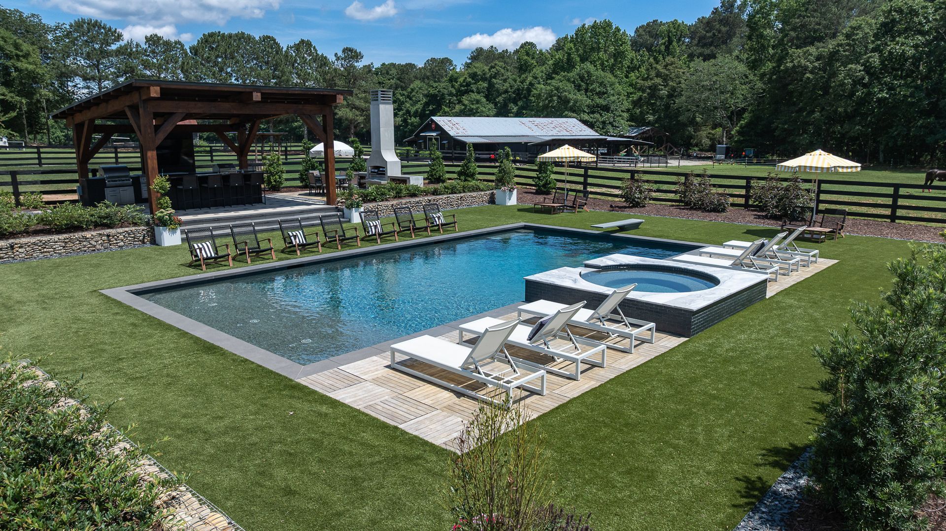 Backyard pool with hot tub, lounge chairs, and a gazebo on a sunny day