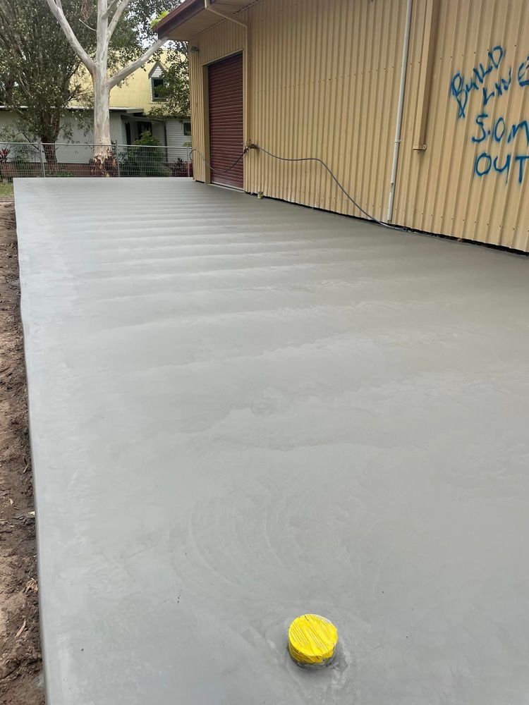A Concrete Driveway Is Being Built in Front of A Building — J’s Concreting & Carpentry in Laurieton, NSW