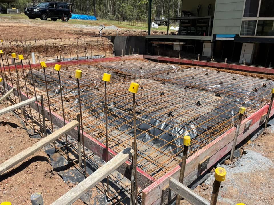 A Construction Site with A House in The Background — J’s Concreting & Carpentry in Laurieton, NSW
