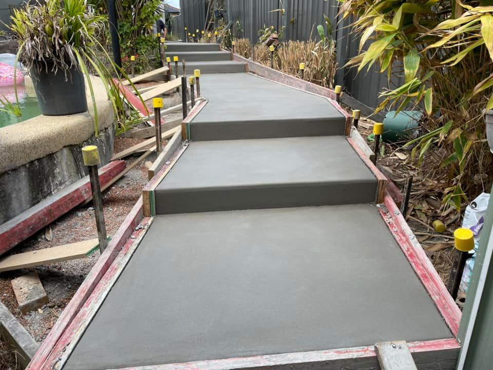 A Concrete Walkway with Stairs Being Built in A Garden — J’s Concreting & Carpentry in Lake Cathie, NSW