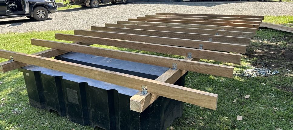 A Wooden House Is Being Built with A Ladder and Stairs — J’s Concreting & Carpentry in Kew, NSW