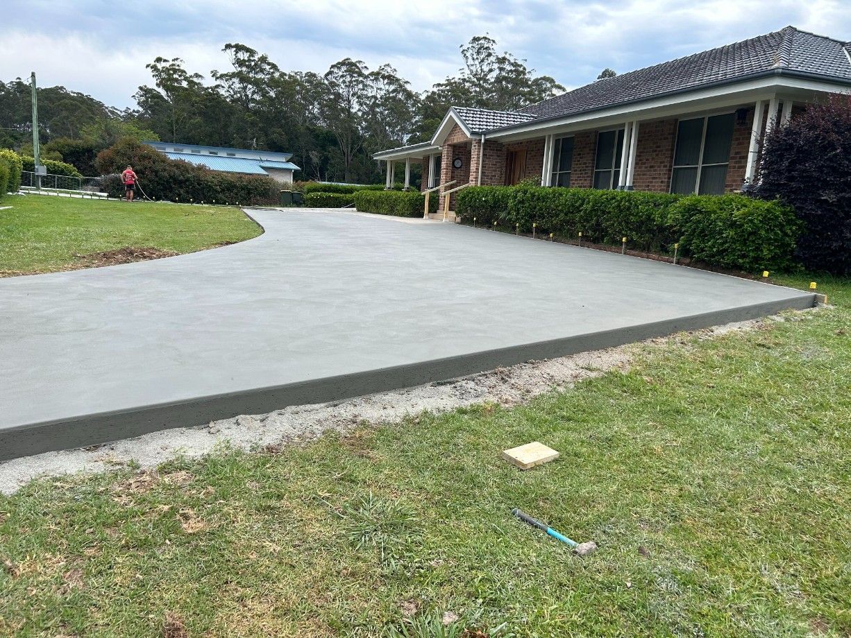 A Brick Wall Is Being Built Next to A Concrete Slab — J’s Concreting & Carpentry in Kew, NSW
