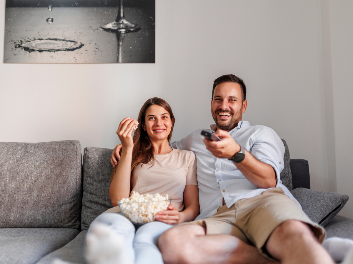 man an woman enjoying tv with bluetooth hearing aids