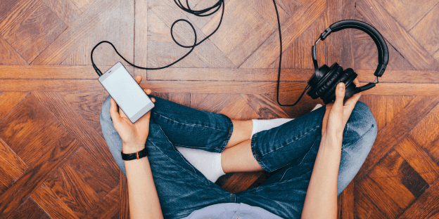 person holding headphones plugged into a phone and practicing safe listening