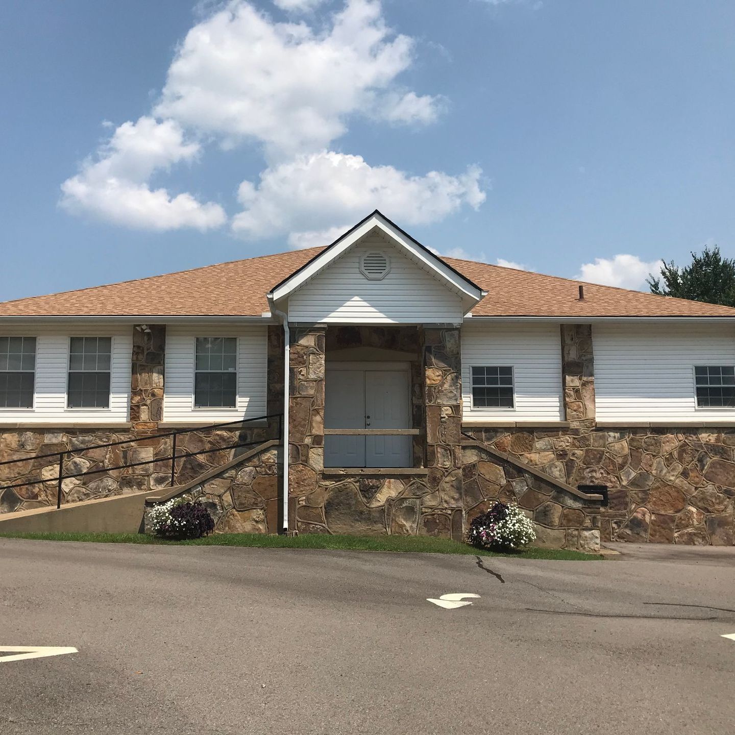 Plumerville Criminal Lawyers A white house with a stone wall and a roof