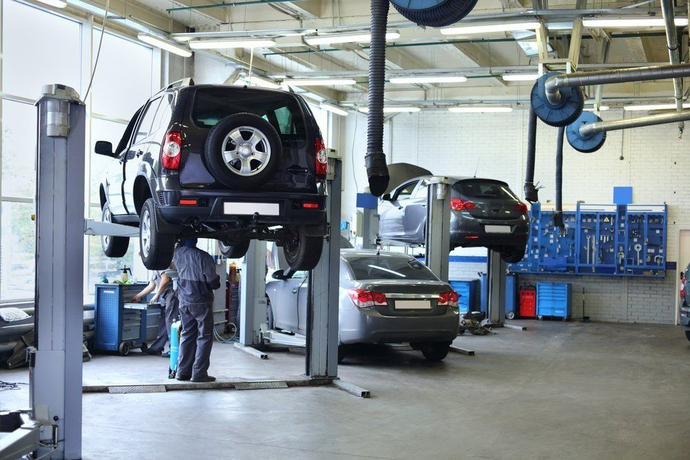 A Man Is Working on A Car in A Garage — Al's Mechanical & 4WD Grafton Repairs in Grafton, NSW
