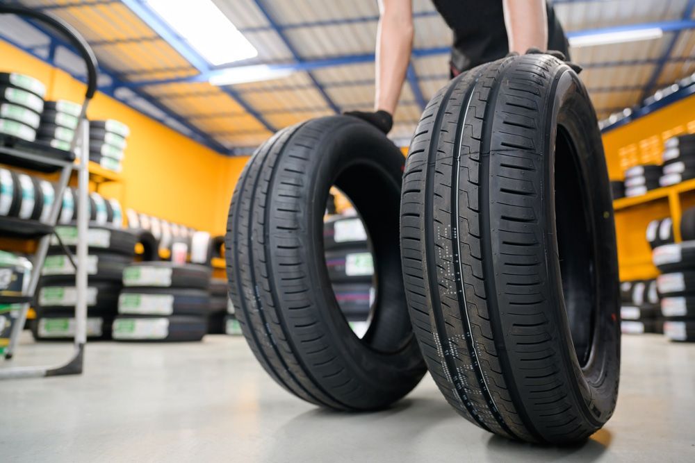 Man Holding Two Vehicle Tyres