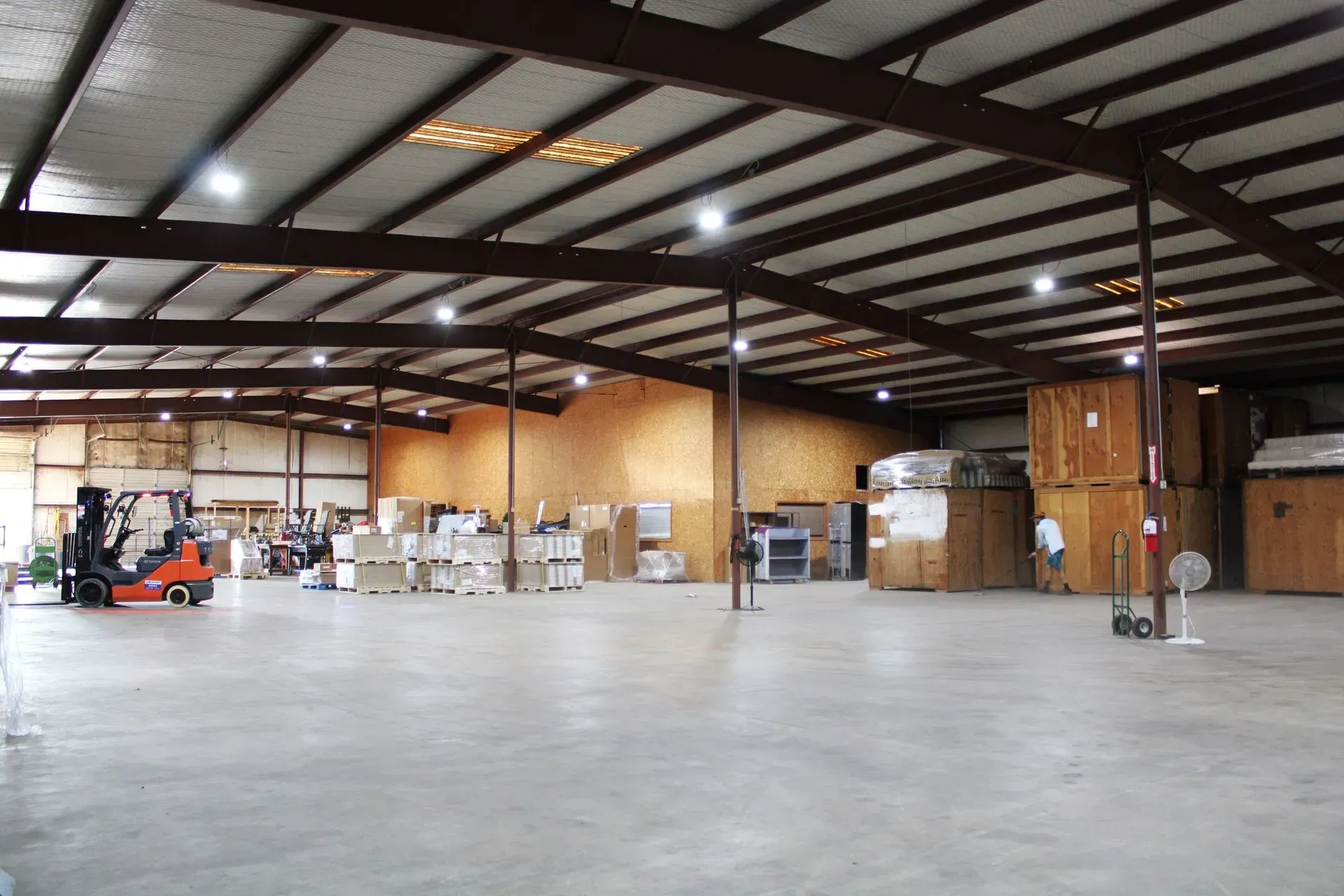 A large warehouse with a forklift in the middle