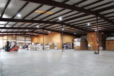 A large warehouse with a forklift in the middle