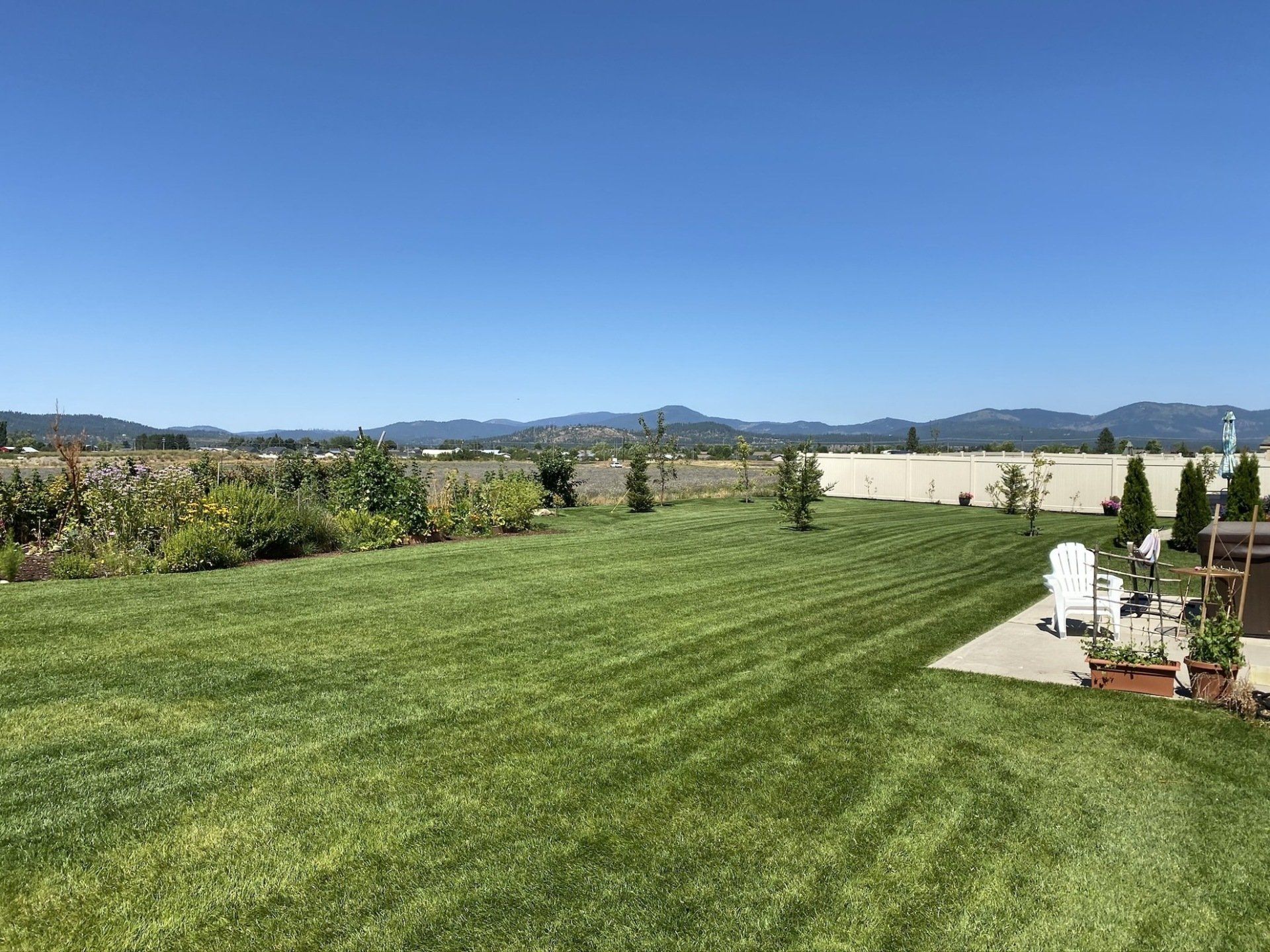 A large lush green lawn with mountains in the background.