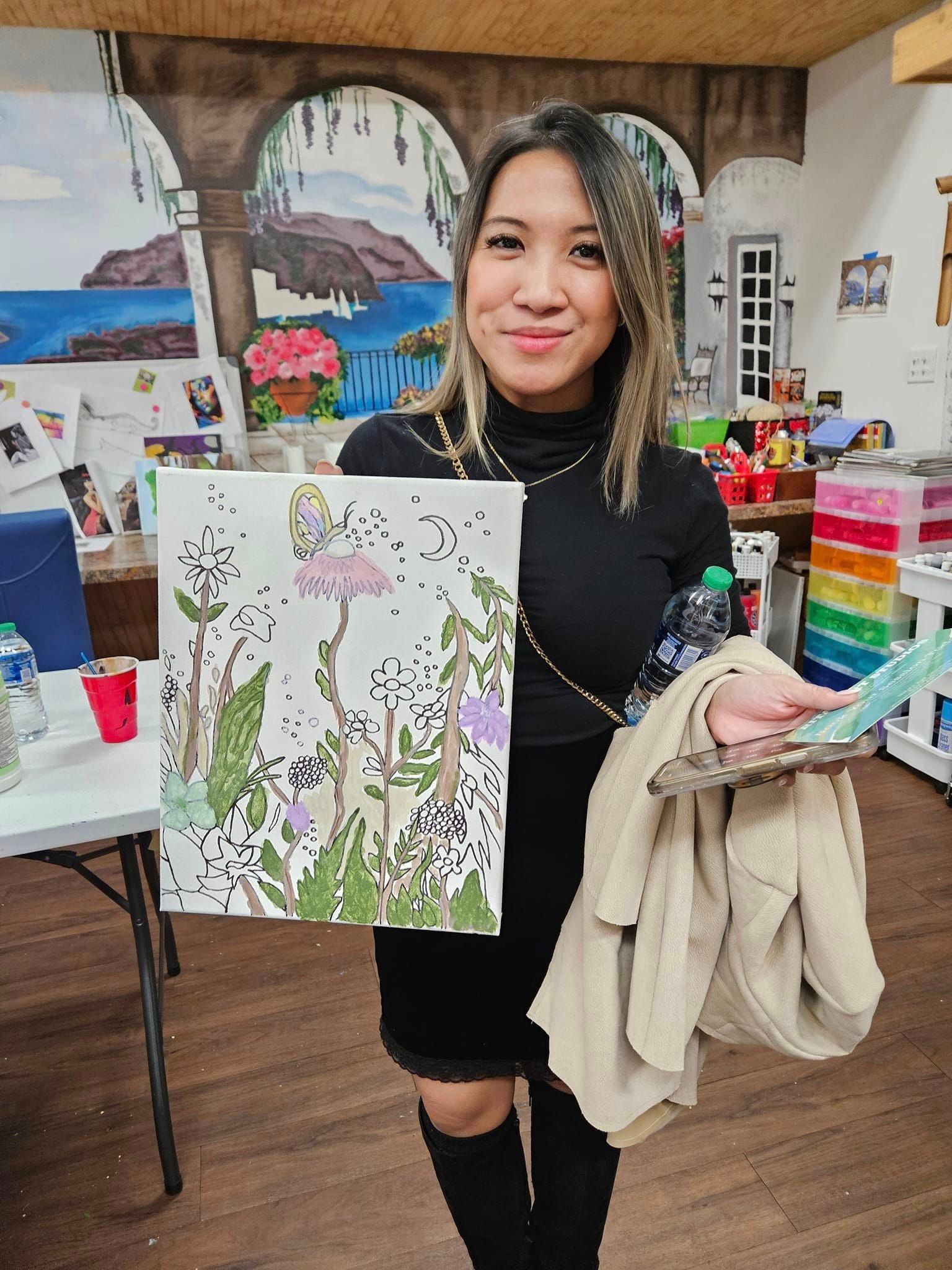 A woman is holding a painting of flowers in a room.