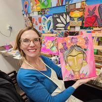 A woman is holding a painting of a woman with flowers in her hair.