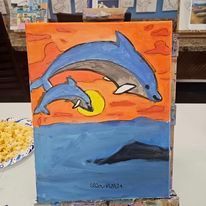 A painting of two dolphins swimming in the ocean at sunset.