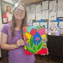A woman is holding a painting of a tulip in a room.