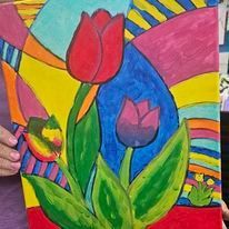 A person is holding a painting of a flower on a canvas.