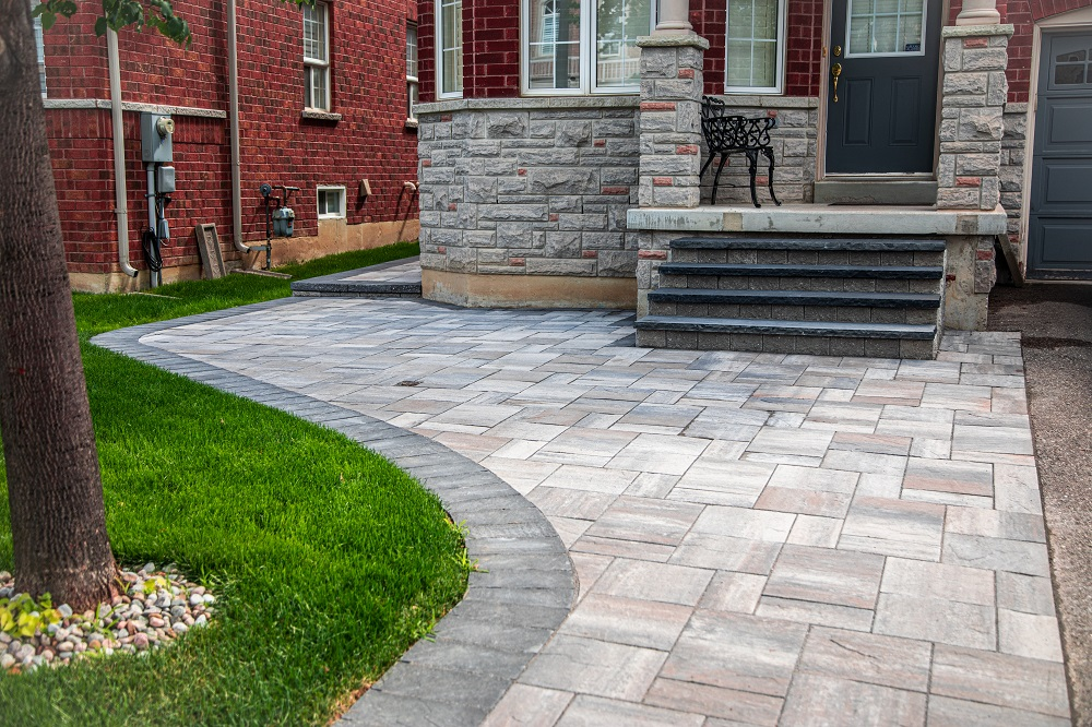 A stone walkway leading to the front door of a brick house.