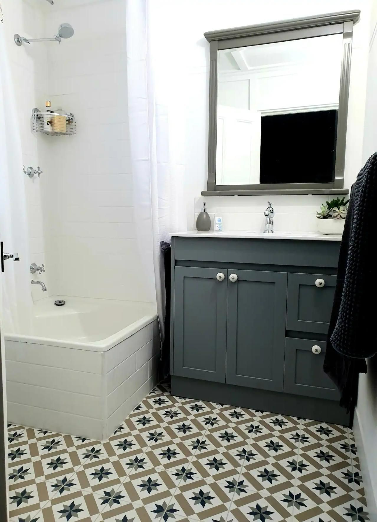 Bathroom With Black Cabinet And A Big Mirror — Accommodation in Forbes, NSW