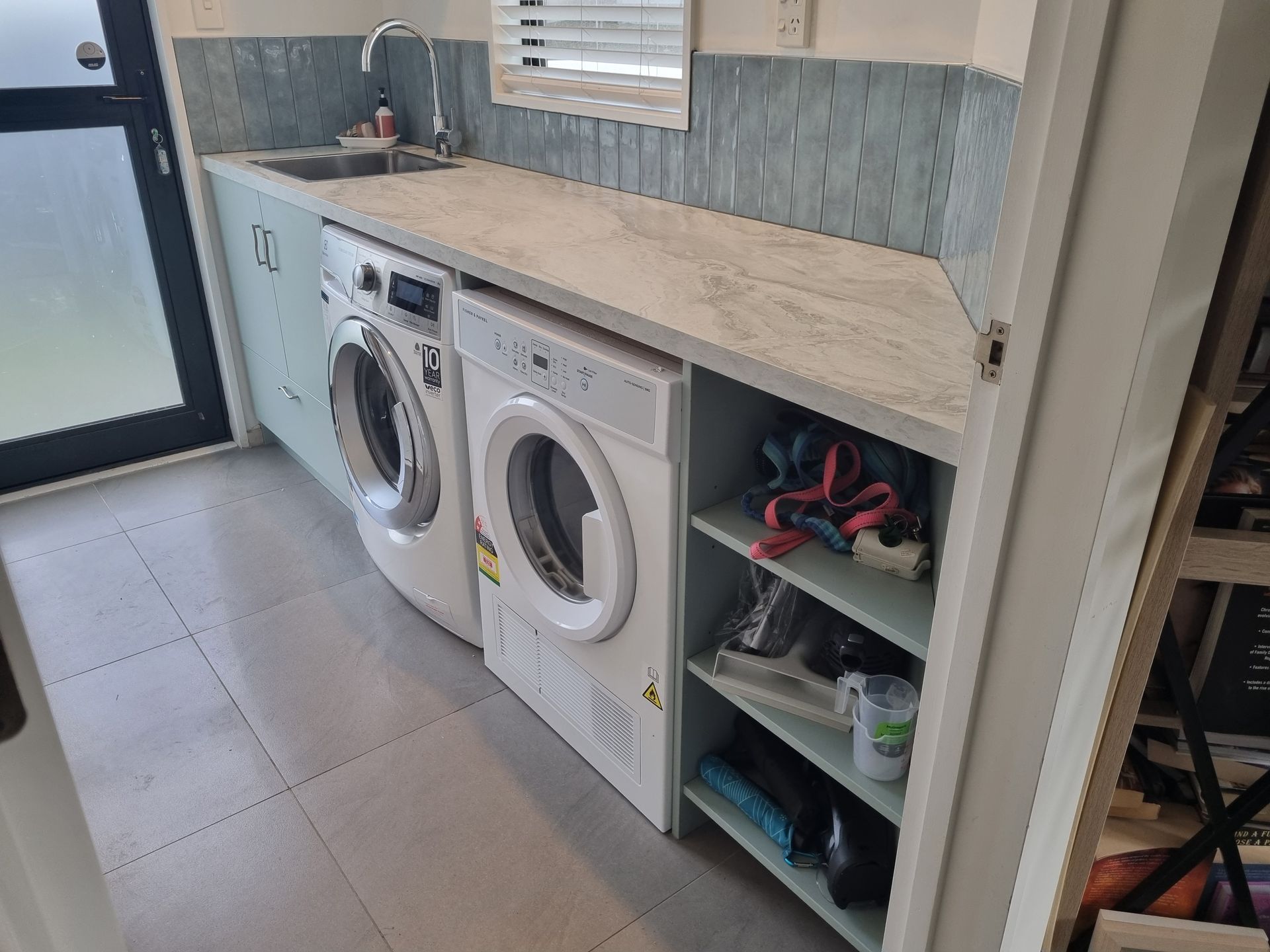 Custom Christchurch laundry with stone-look benchtop and tiled splashback