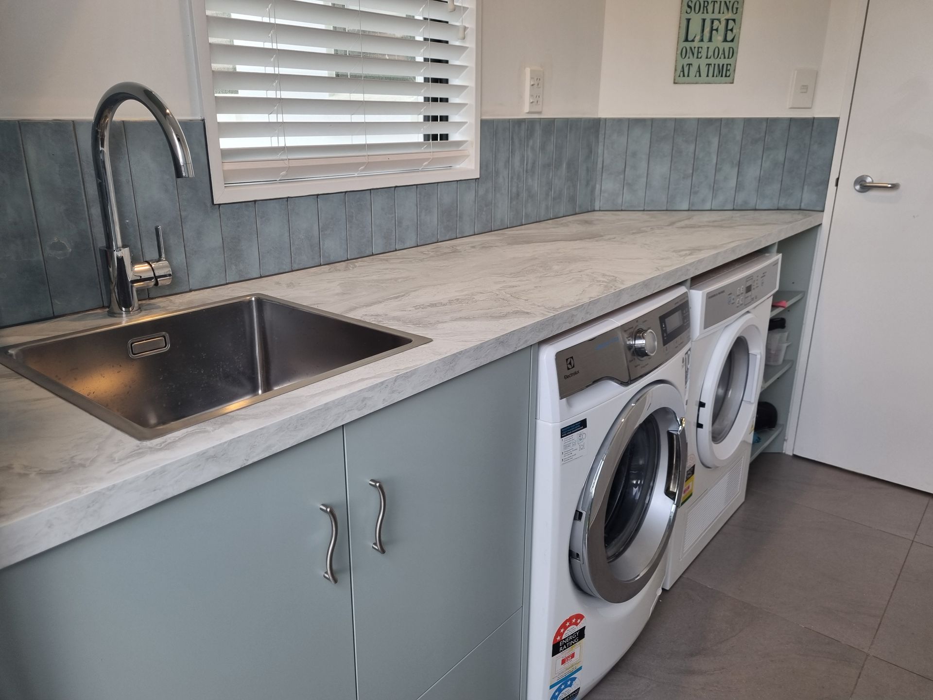 Angled custom corner cupboard in a renovated laundry