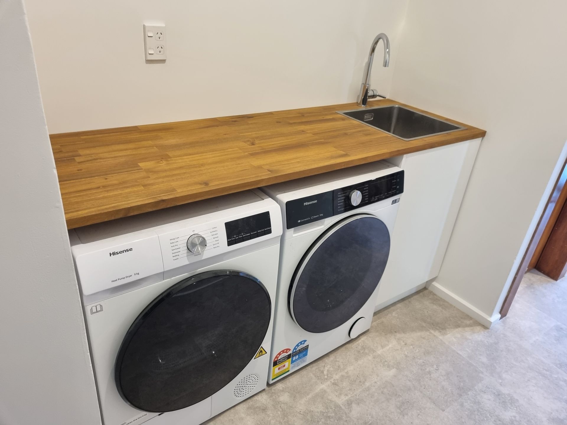 Laundry sink and cabinetry detail beside a timber benchtop