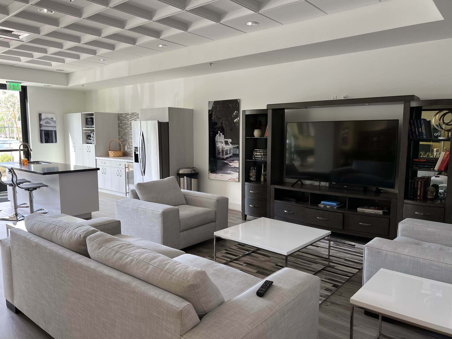 Monticello Apartments lounge TV area with kitchen and seating