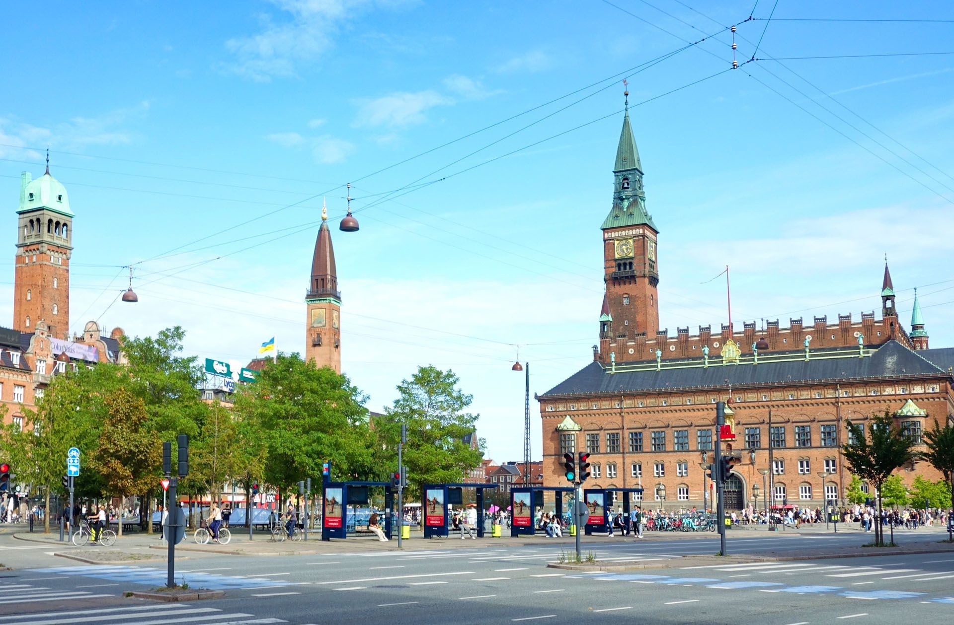 Wide city square with historic brick buildings and towers under a clear blue sky