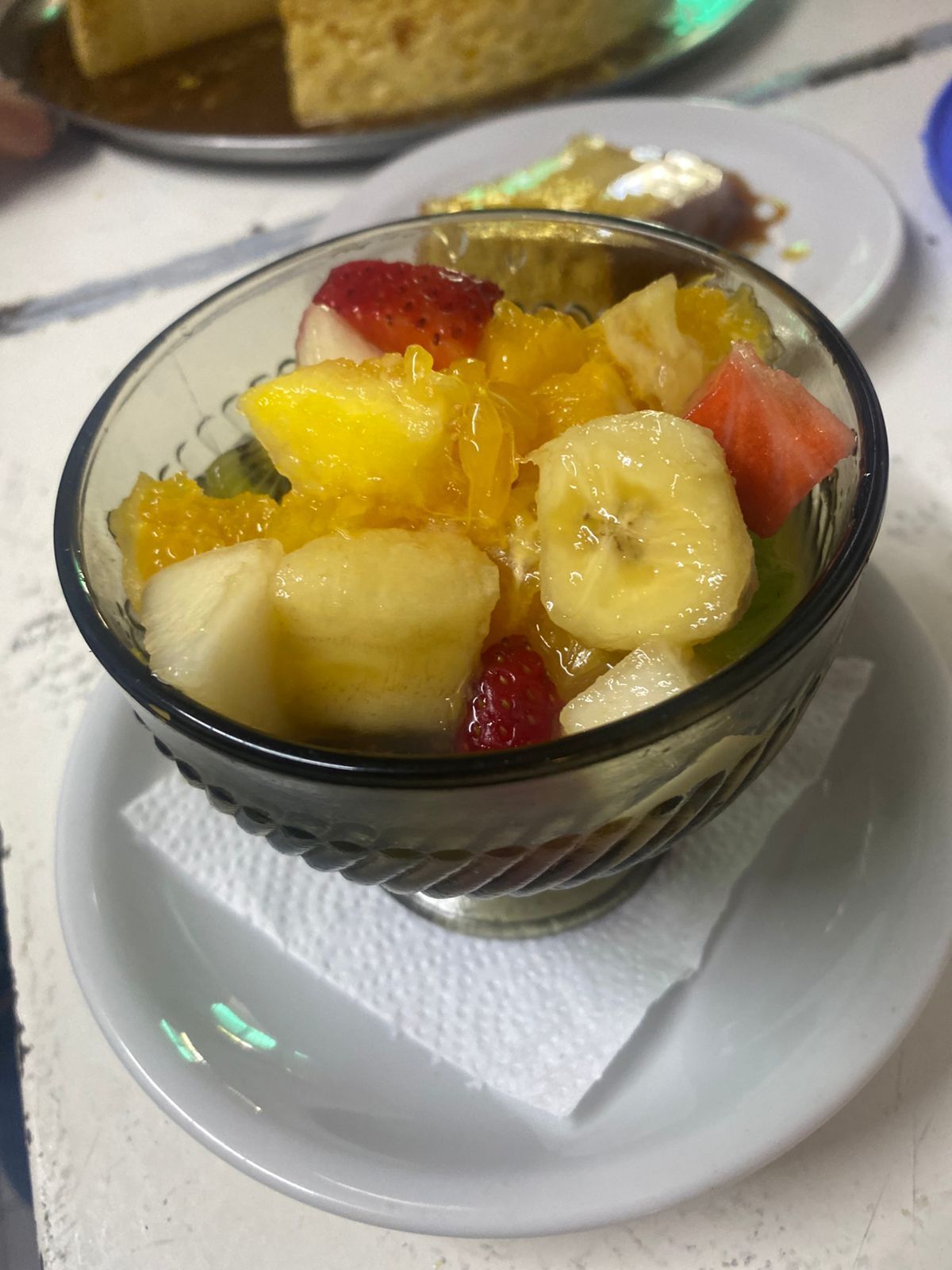 Un cuenco de cristal lleno de una colorida ensalada de frutas variadas 