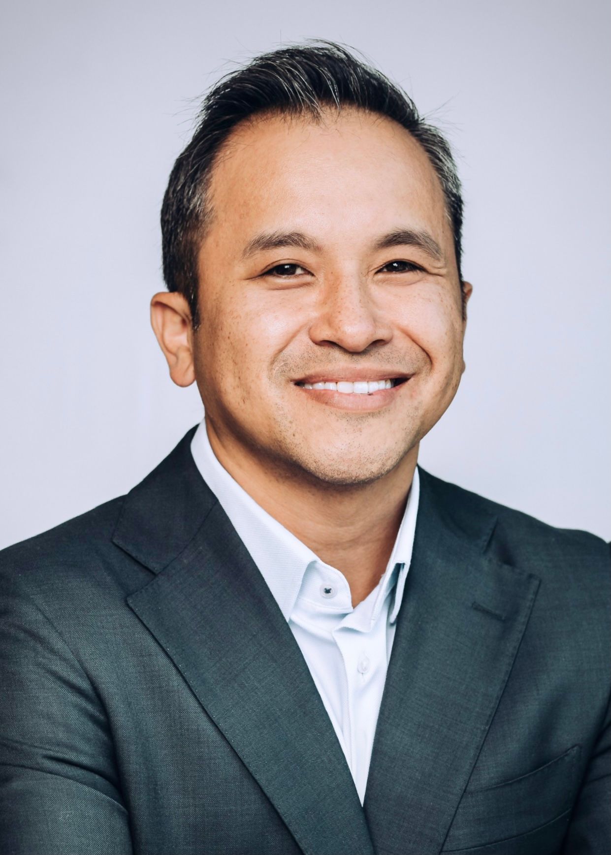 a portrait of Dr. Dennis Nguyen, Board-Certified Dermatologist & Fellowship-Trained Mohs Surgeon wearing a suite