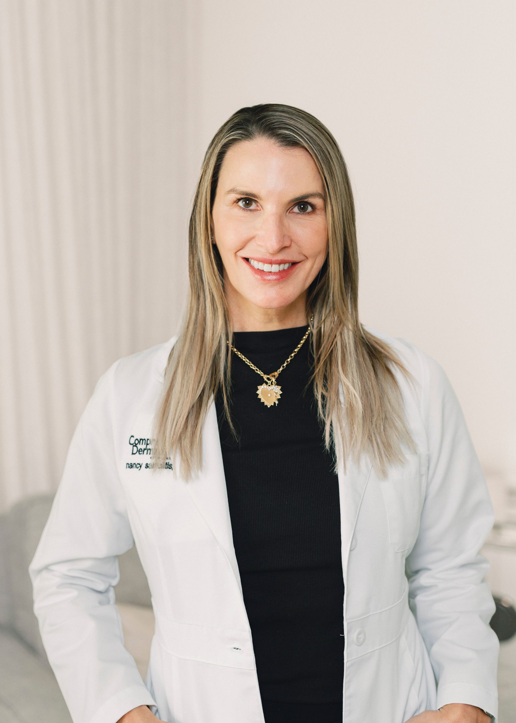 a portrait of Dr. Nancy Samolitis, Board-Certified Dermatologist wearing a white blouse