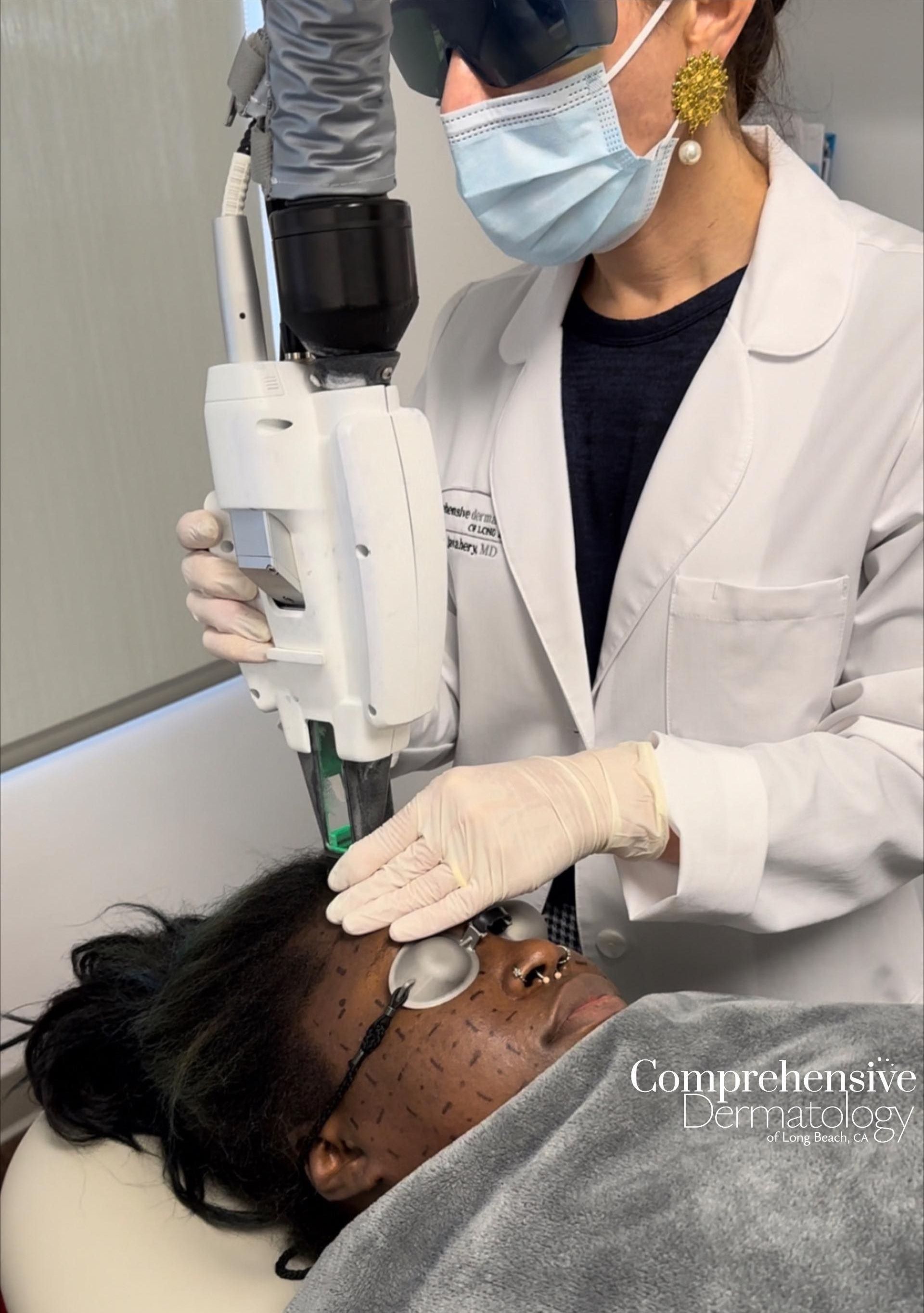 Dr. Jahavery applying accure laser treatment on female patient's face