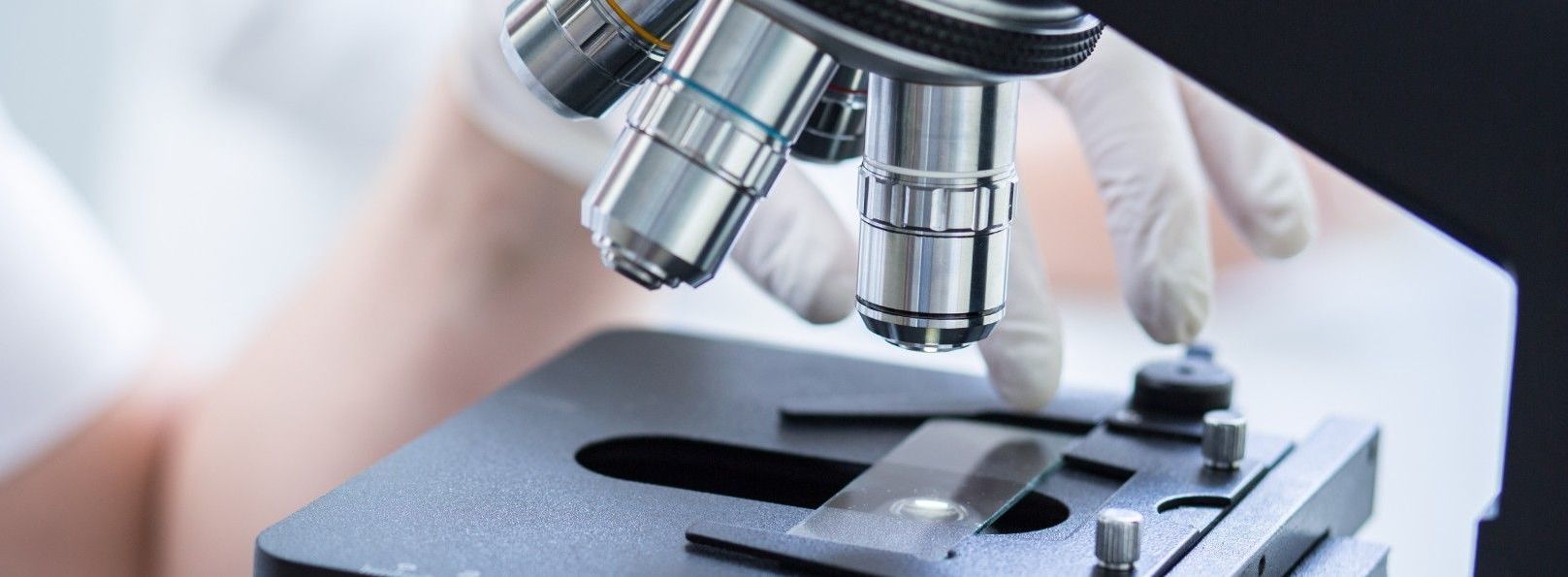 closeup of scientist using microscope