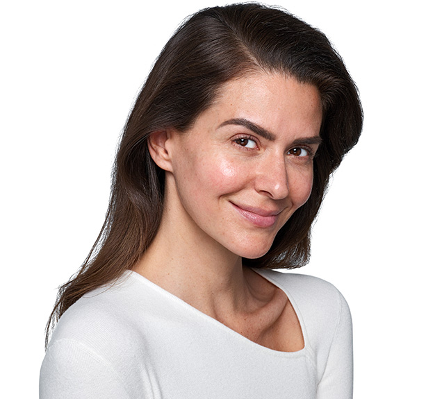 a woman with curly hair is looking at the camera