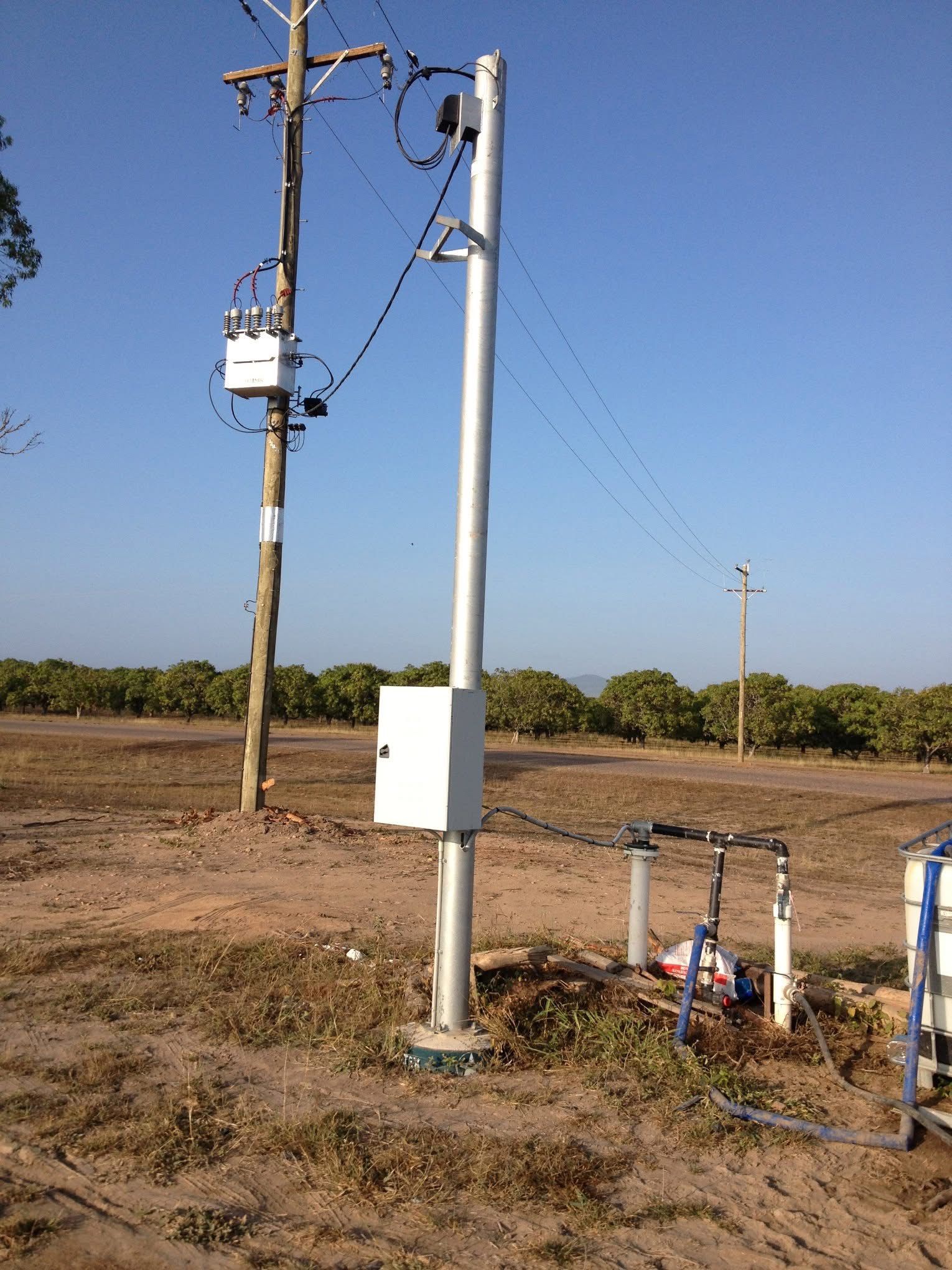 Lineman In Blue Uniform On Ladder, Working On A Power Pole Against A Blue Sky — Stanayr Electrical in Gulliver, QLD