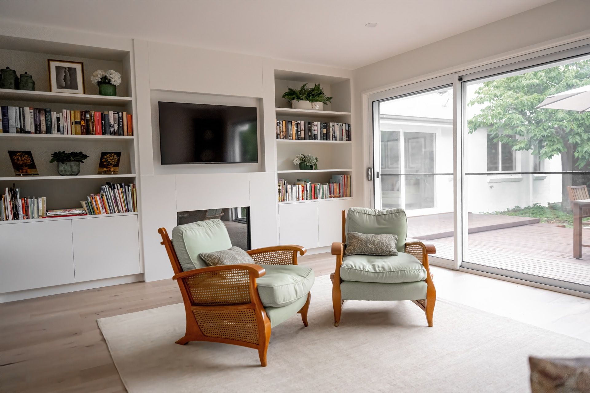 Bright Living Room With Wicker Chairs, Built-in Shelves, and Large Sliding Glass Doors — Prime Built Group in Mittagong, NSW