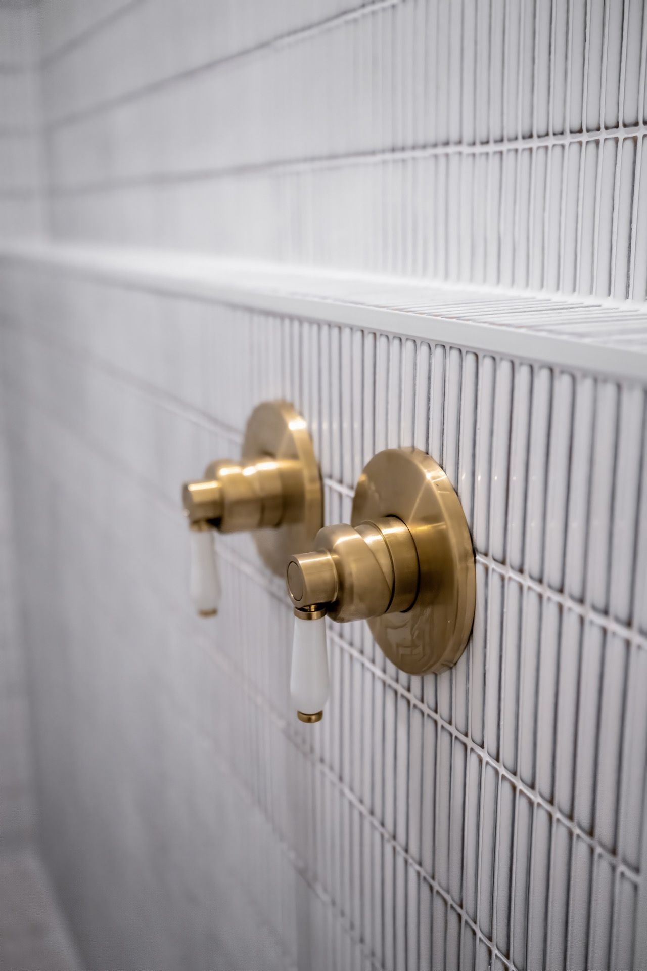 Two Brass Shower Controls Mounted on White Tiled Wall — Prime Built in Bowral, NSW