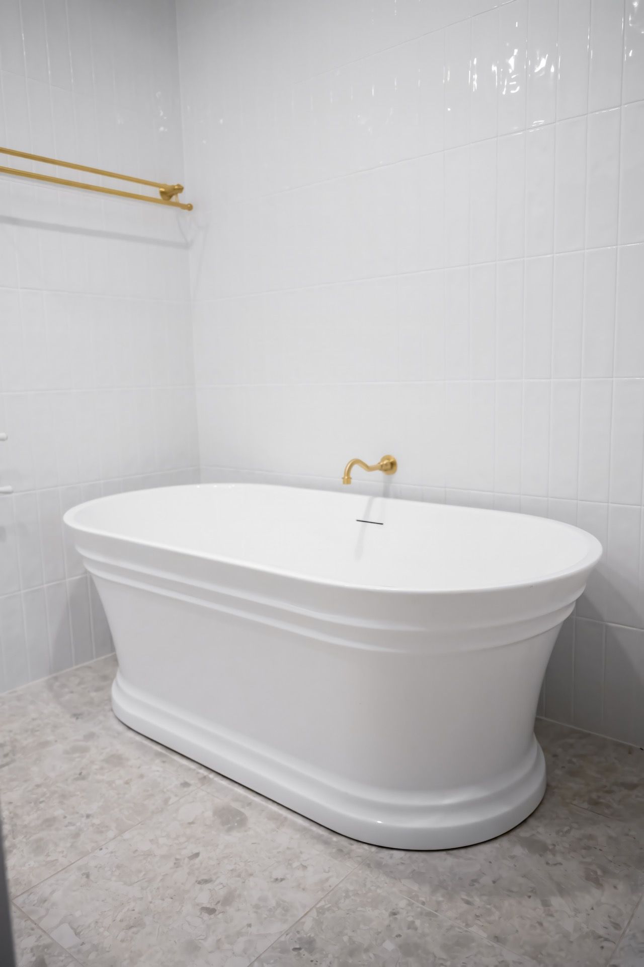 Freestanding White Bathtub in a Bright Tiled Bathroom — Prime Built in Bowral, NSW