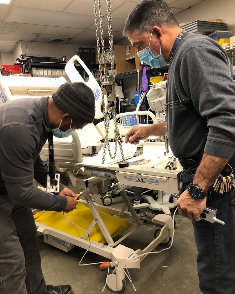 Two man repairing a medical equipment