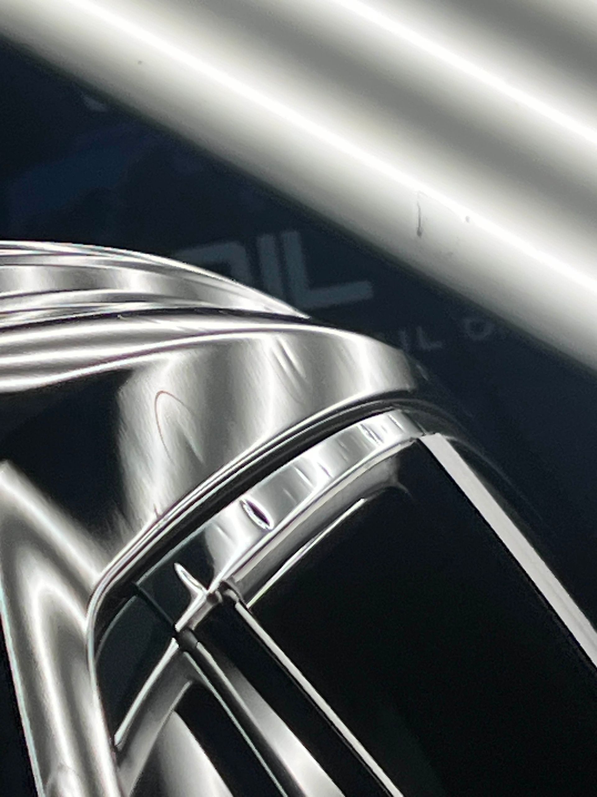 Shiny car surface with light reflections, revealing small dents.