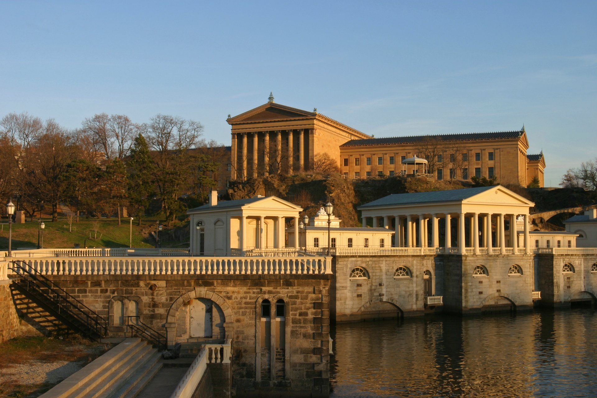 A bridge over a body of water with a large building in the background