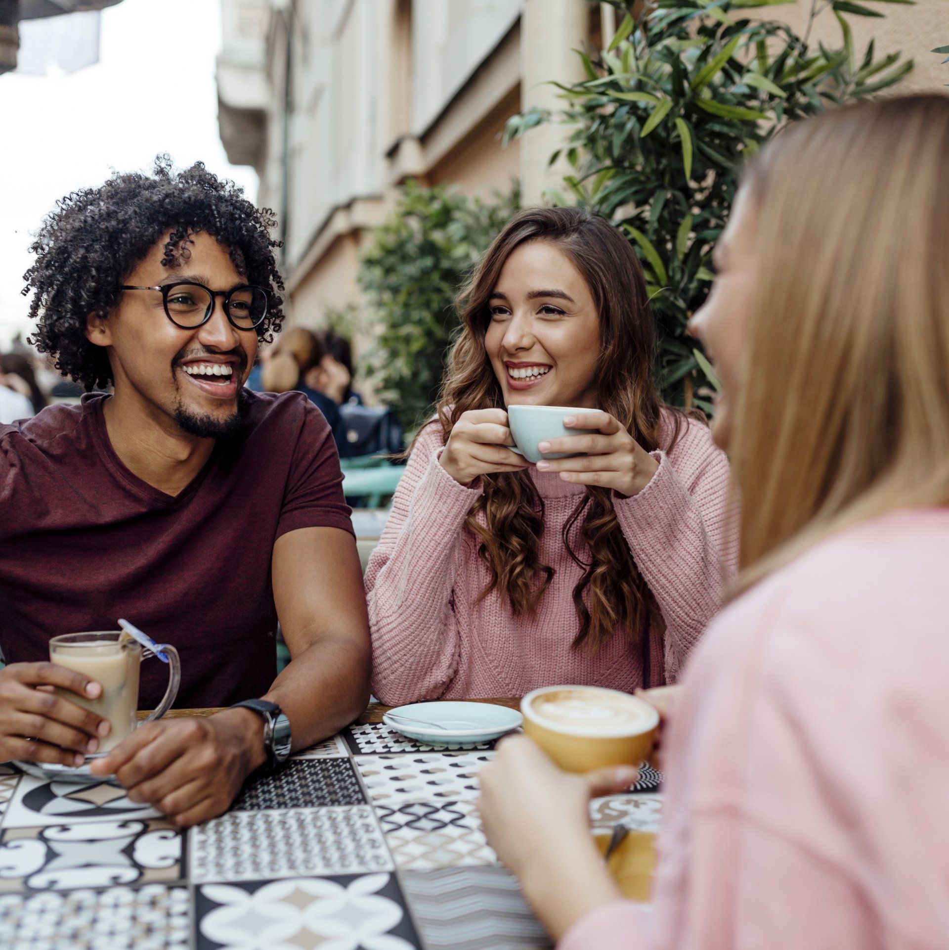 A group of people are sitting at a table drinking coffee.