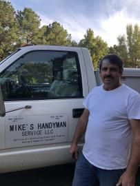 A person standing in front of a white truck labeled 