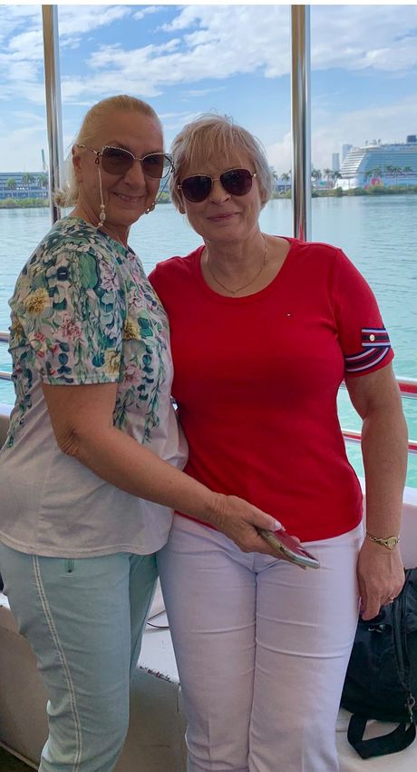 Two women enjoying the Miami boat tour with the skyline and cruise ships in the background