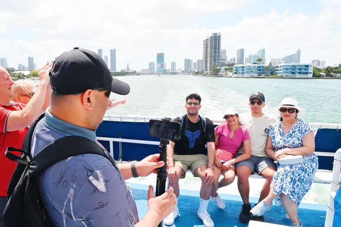Tourists enjoying Bayside boat tours in Miami with stunning skyline views, Miami sightseeing cruise with family and friends capturing photos on the water