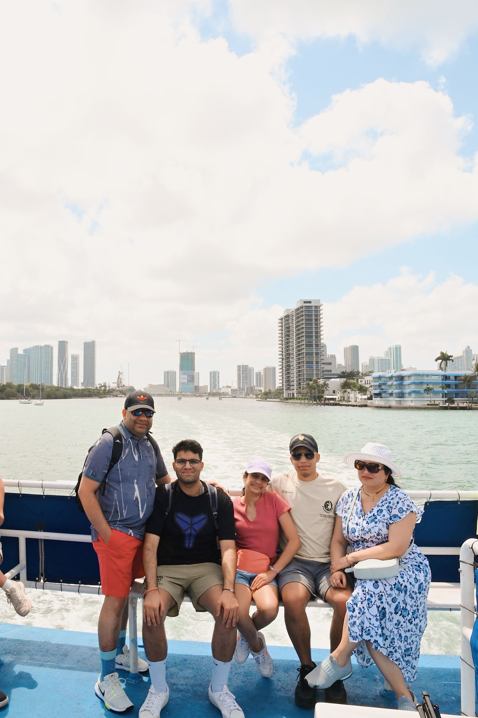 A family taking photos on the Miami Skyline Sightseeing Cruise with the Miami Skyline in the Background