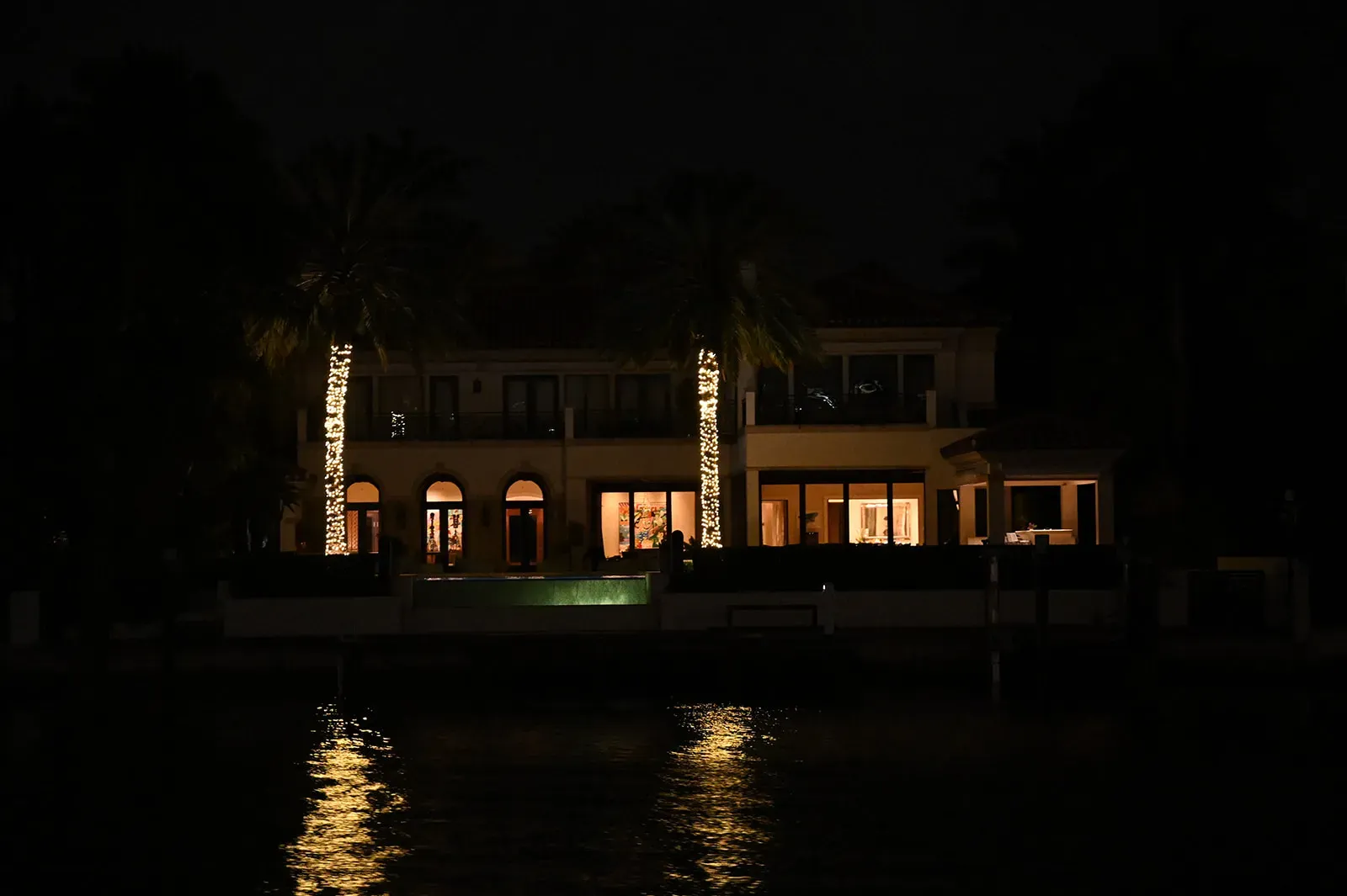 Luxury waterfront estate illuminated at night along Biscayne Bay in Miami